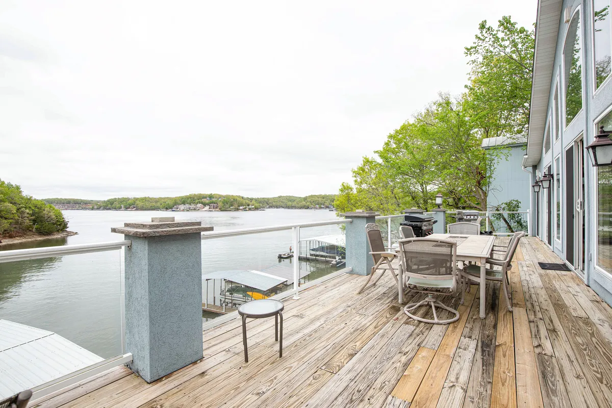 This exterior image features a waterfront view complete with a spacious dining table and comfortable outdoor seating set against a backdrop of serene trees and calm water. The scene exudes a sense of tranquility and invites groups to gather for meals, celebrations, or simply to enjoy the outdoors together.