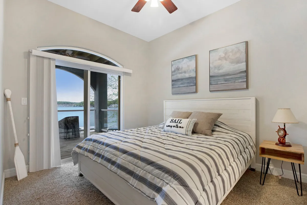 A serene private bedroom featuring a comfortable bed with decorative pillows, a window offering natural light and a view, tasteful artwork on the walls, and a bedside lamp creating a peaceful atmosphere.