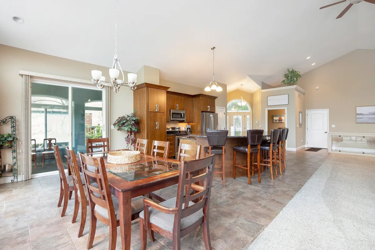 A beautifully arranged dining area with a large table, adjacent kitchen island, and generous windows that frame scenic views. Reclining chairs and an inviting layout foster both casual gatherings and formal meals, echoing the sense of celebration and shared experiences.